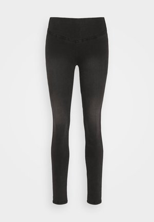 Svarta leggings tillverkade av elastisk tyg, med ett elastiskt midjeband och en slät textur. Kroppsnära design, inga märkbara mönster.