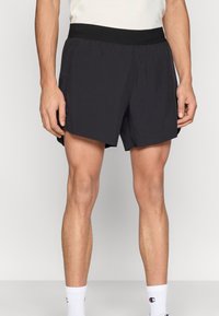 Μαύρο αθλητικό σορτς με ελαστική μέση, απαλό ύφασμα και πλαϊνές τσέπες. Διαθέτει άνετη γραμμή και μήκος πάνω από το γόνατο.