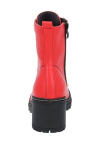 Stivaletto in pelle rossa con tacco spesso nero, zip laterale e dettagli cuciti. Texture liscia e design con punta arrotondata.