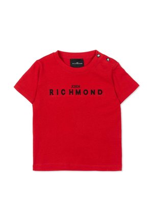 Czerwona, krótka koszulka niemowlęca z czarnym napisem "John Richmond" na przodzie oraz dwoma czarnymi guzikami na lewym ramieniu z białym logo "JR".