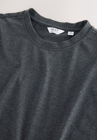 Dunkelgraues T-Shirt mit Rundhalsausschnitt, mit einem "NEXT" Markenlabel und einem mittelgroßen Größenetikett innen am Kragen.