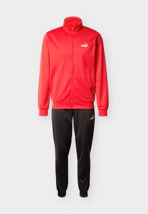 Giacca sportiva rossa con zip e collo alto, abbinata a pantaloni della tuta neri con taglio affusolato. Entrambi hanno una texture liscia e presentano il logo Puma.