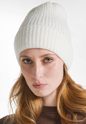 Witte geribbelde gebreide beanie met een zachte textuur, met een lichte slouch bovenaan en een goede pasvorm rond het voorhoofd.