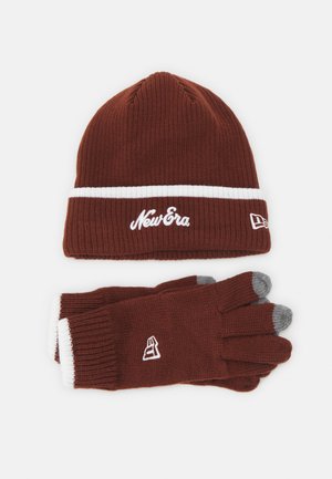 Beanie tricot marron avec une rayure blanche et le logo "New Era" ; gants marron assortis avec des accents blancs et des bouts de doigts gris pour les écrans tactiles.