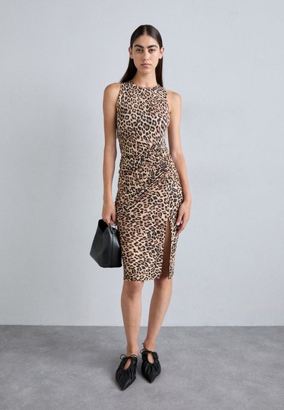 Leopard print, fitted dress with a side slit, made of stretchy fabric. Paired with a black structured handbag and textured black shoes.