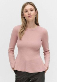 Pull à manches longues en maille côtelée de couleur rose clair, corps ajusté avec un ourlet évasé, encolure ronde et texture lisse. Détails de design minimalistes.