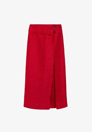 Falda midi roja con una abertura frontal y una cintura asimétrica con pequeños botones decorativos.