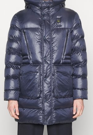 Navyblauw gewatteerd jack met knoopsluiting, borstzakken met rits, klepzakken voor de handen en een klein stoffen logo op de bovenborst.