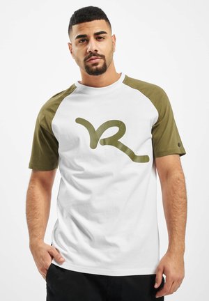 Hvid T-shirt med olivengrønne raglanærmer, prydet med et stort grønt stiliseret "R"-grafik på forsiden. Glat stoftekstur.