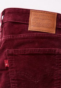 Pantalon en velours côtelé marron avec poche arrière et étiquette en cuir marron Levi Strauss & Co. cousue au-dessus de la poche.