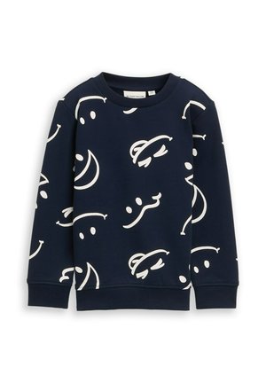 Tumesinine puuvillaseguses kampsun, millel on valged abstraktsed mustrid. Omab pikki varrukaid, ümmargust kaelust ning soonikuid mansette ja äärt.