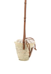 Geflochtene Strohtasche für die Schulter mit einem beigen Innenfutter aus Stoff, braunem Lederriemen und Kordelzugverschluss. Zylindrische Form mit natürlicher Textur.