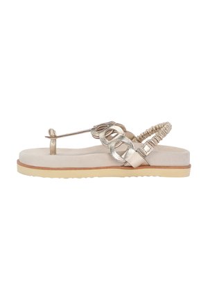 Sandal in oro metallico con suola piatta, caratterizzata da un design a t-strap, una soletta imbottita e un cinturino posteriore elasticizzato per il massimo comfort.