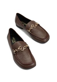 Brązowe, teksturowane mokasyny ze skóry z ozdobą w postaci złotego skręconego łańcuszka na górze, czarnym wnętrzem i płaskimi czarnymi podeszwami.