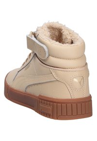 Baskets montantes en cuir tan avec doublure en fourrure, sangle Velcro et semelle en caoutchouc texturé marron. Présente un logo sur le côté.