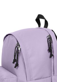 Zaino viola con una superficie in tessuto liscio, dettagli in metallo neri e lacci per la chiusura. Il design include una maniglia superiore.