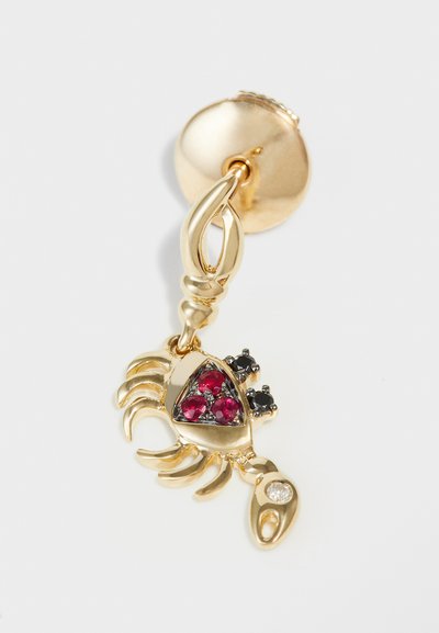 Gold scorpion earring with claws and tail design, featuring red and black gemstones, and a textured backing for secure wear.