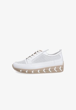 Witte sneaker met geperforeerde bovenzijde, beige dikke zool met witte chevronpatronen en witte veters, gezien vanaf de zijkant.