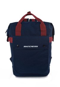 Mochila azul marino con correas rojas. Presenta un bolsillo frontal, cierre con cremallera y el logo "SKECHERS" en la parte inferior del frente. Fabricada con tela duradera.