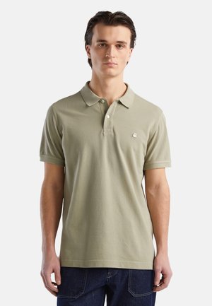 Camisa polo de algodón en verde oliva claro, con mangas cortas, un cuello clásico, tres botones y un pequeño logotipo bordado en el pecho.