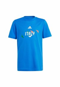 T-shirt in cotone blu con la scritta "ITALIA" in bianco, arricchita da accenti geometrici verdi e rossi. Logo Adidas posizionato sopra il testo. Maniche corte, colletto rotondo.