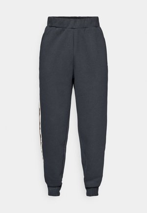 Dark gray sweatpants made of soft fabric, featuring a tapered fit, elastic waistband, and contrasting side stripes with a smooth texture.