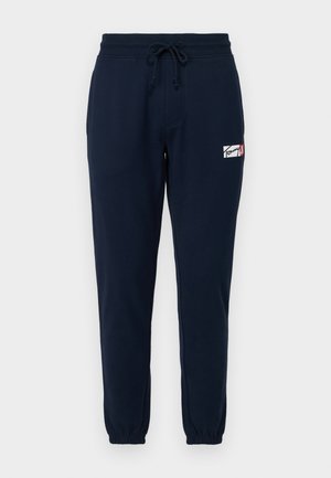 Navy Jogginghosen aus weichem Baumwollmischgewebe, mit elastischem Bund und Kordelzug, Seitentaschen und einem kleinen Logo-Patch.