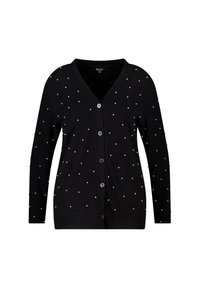 Zwart vest met een V-hals, voorzien van wit parelachtig versieringen verspreid over de stof. Gemaakt van zacht materiaal, knoopsluiting.