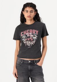 Black short-sleeved t-shirt featuring a cherry graphic design with floral accents, slightly cropped fit, and raw edge hem.