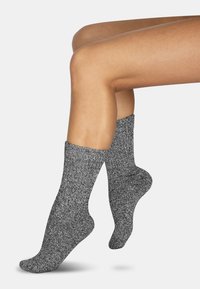 Graue, strukturierte Socken mit einem gerippten Bündchen, mittellang bis zur Wade, mit einem melierten Muster und einer glatten Sohle für Komfort.