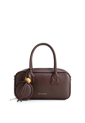 Sac à main rectangulaire en cuir marron foncé avec des poignées arrondies et une petite pochette circulaire attachée avec un détail perle en bois et pompon.