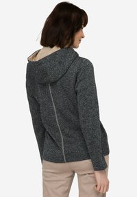 Mörkblå hoodie med en strukturerad stickad design, med en kontrasterande krämfärgad foder, framzip och en avslappnad passform.