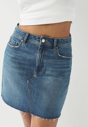 Denim minikjol med fransat fåll, ljusblå tvätt, femfickorsdesign och kopparfärgad hårdvara. Klassisk passform, avslappnad stil.