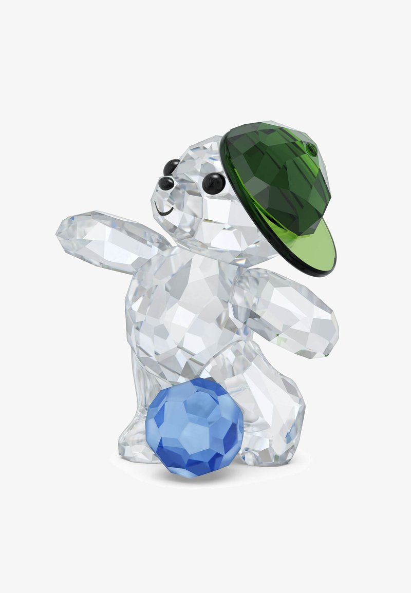 Figura di orso in cristallo trasparente che indossa un berretto da baseball verde in cristallo, posando con un braccio teso e una sfera di cristallo blu sfaccettata.