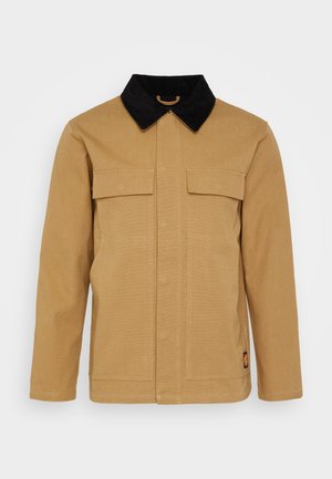 Bruine lange-mouwen jas met zwarte kraag, twee borstflapzakken en een klein logopatchje dichtbij de onderzoom aan de rechterkant.