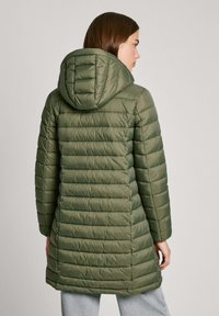Olivgrön puffjacka med huva, med quiltade sömmar och en något avsmalnande passform. Tillverkad av ett mjukt och lätt tyg.
