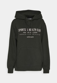 Sweat à capuche vert foncé avec poche sur le devant et texte imprimé blanc indiquant "SPORTS & HEALTH CLUB" et "BJÖRN BORG" sur le devant.