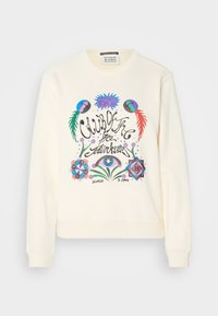 Kremowy sweatshirt z kolorową grafiką przedstawiającą kwiatowe elementy oraz napisem "Klub Wolnych Duchów" w artystycznym kroju pisma.