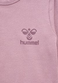 Roze sweatshirt van een textuurrijke, zachte stof. Kenmerkt zich door een centraal logo met een gestileerd bijontwerp en de tekst "hummel" eronder.