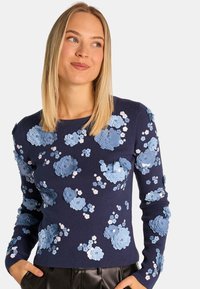 Dunkelblauer Pullover mit 3D-Blumenapplikationen in Hellblau und Weiß. Gerippte Textur und lange Ärmel. Figurbetontes Design, geeignet für legere Anlässe.