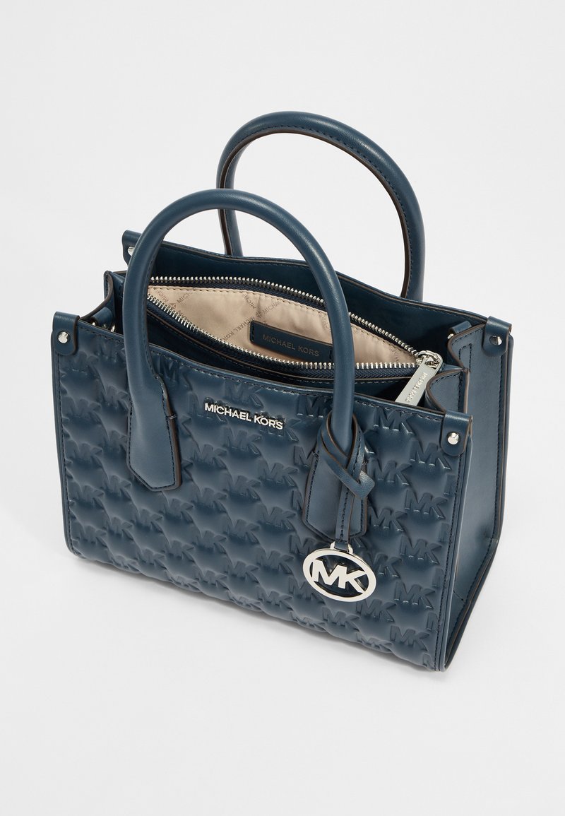 Borsa a tracolla sintetica blu navy con motivo a logo in rilievo, manici superiori doppi, chiusura con zip e dettagli in metallo lucido argento. Fodera interna beige.