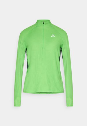 Maglia sportiva a maniche lunghe in verde acceso, con collo con zip a un quarto, tessuto strutturato e dettagli laterali neri a contrasto.
