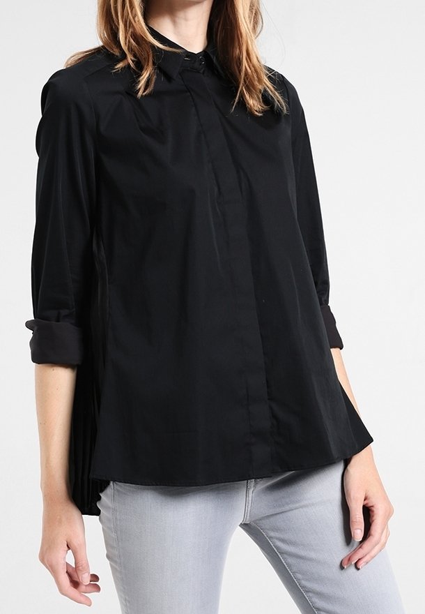 Black button-up shirt with a collared neck. Features long sleeves rolled at the cuffs and a loose fit, made from a smooth, sleek fabric.