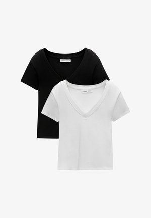 Kaksi V-kaulaista t-paitaa mustana ja valkoisena. Lyhyet hihat, pehmeää puuvillakangasta, ommeltu reuna ja rento malli.