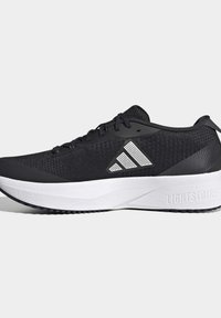 Chaussure de sport noire avec semelle blanche coussinée, dessus en mesh et un logo triangulaire blanc sur le côté. La semelle est marquée "LIGHTSTRIKE."