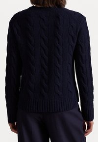 Laivastonsininen palmikkoneulepaita, jossa on kuvioitu rakenne, resoriset hihansuut ja helma sekä klassinen pyöreä kaula-aukko.