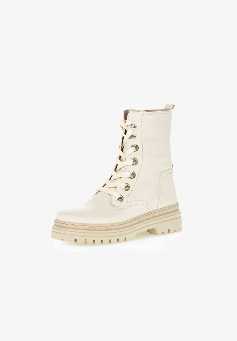 Bottine beige à lacets avec semelle épaisse, œillets métalliques et languette à l'arrière, conçue pour un usage décontracté ou robuste.