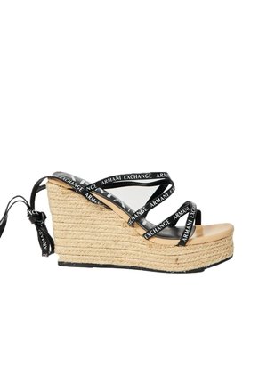 Sandali con zeppa e piattaforma in corda naturale, dettagli neri con cinghie e logo, e una suola in beige liscia.