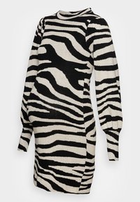 Robe tricotée rayée zèbre noire et crème, manches longues bouffantes, encolure ronde, silhouette ajustée avec un détail froncé sur le côté.