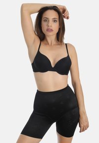 Schwarzer BH mit geformten Cups und verstellbaren Trägern, kombiniert mit hochgeschnittenen Shaping-Shorts, die ein dezentes Blumenmuster aufweisen.